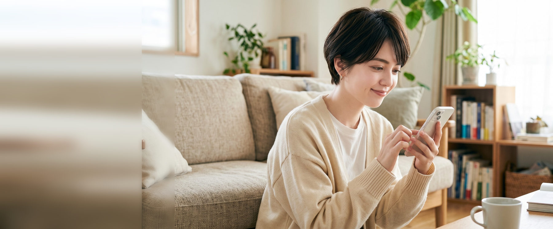 ご自宅のソファでスマートフォンからオンライン診療を受ける女性